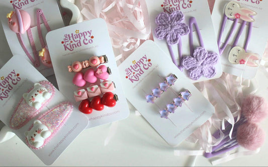 Set of children's hair accessories on cards with 'Happy Kind Co' branding.